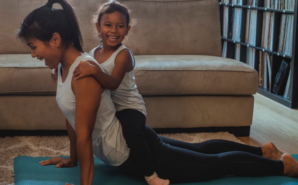 Une femme et sa fille faisant du yoga